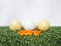 Photo of golf balls and orange tees on artificial grass with white background Royalty Free Stock Photo