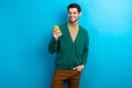 Photo of good mood cute man wear green cardigan spectacles communicating modern device isolated blue color background Royalty Free Stock Photo