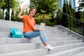 Photo of good mood friendly girl dressed orange t-shirt eyewear waving arm hi browsing modern device outdoors urban town