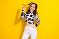 Photo of good mood gorgeous girl with curly hairdo dressed cow long sleeve arm in pocket hold curl isolated on yellow Royalty Free Stock Photo