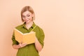 Photo of good mood intelligent woman dressed green shirt in glasses write thoughts in diary book isolated on beige color