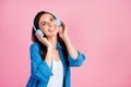 Photo of gorgeous nice girl with straight hairdo dressed blue shirt touch headphones look empty space  on pink Royalty Free Stock Photo