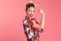 Gorgeous strong young pin-up woman showing biceps. Royalty Free Stock Photo