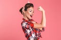 Gorgeous strong young pin-up woman showing biceps. Royalty Free Stock Photo