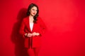 Photo of gorgeous sweet lovely lady fix button on jacket wear trousers isolated over red bright color background Royalty Free Stock Photo