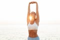 Beautiful young redhead sports woman make stretching exercise outdoors at the beach in the morning Royalty Free Stock Photo