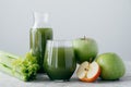 Photo of green smoothie with cerely and apple in two glass containers on white background. Healthy organic juice. Dieting concept Royalty Free Stock Photo