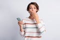 Photo of guilty young woman dressed striped pullover holding modern device arm cover mouth grey color