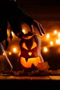 Photo of halloween pumpkin cut in shape of face with witch`s hand Royalty Free Stock Photo