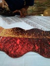 Hand of craftman / artist make a printed batik using stamp