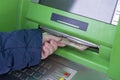 Photo of hand taking from ATM Ukrainian hryvnas