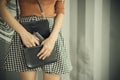 Photo of hand of young woman pulling a pistol out of her handbag