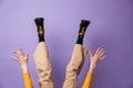 Photo of hands and legs wearing velvet pants and black shoes