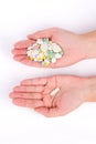 Photo of hands with many pills and one capsule white