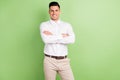 Photo of handsome adorable young guy dressed white shirt hands crossed smiling isolated green color background