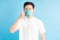 A photo of a handsome asian man drinking from a blue cup