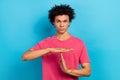 Photo of handsome confident man with perming coiffure wear pink t-shirt hands showing pause break on blue color