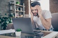 Photo of handsome focused serious tired guy sit sofa work morning overwhelmed loaded browsing notebook freelancer remote