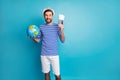 Photo of handsome funky guy hold world globe traveler prepare tickets wait flight check-in wear striped sailor shirt