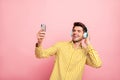 Photo of handsome guy holding telephone hands recording video with new earflaps new post with modern review wear hipster