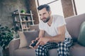 Photo of handsome guy homey sit comfy sofa quarantine stay home gamer hold play station joystick good mood fifa Royalty Free Stock Photo