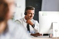 Photo of handsome man 30s wearing office clothes and headset, working on computer in call center Royalty Free Stock Photo