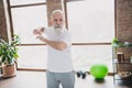 Photo of handsome positive good mood sportive grandfather training stretching spine arms exercise at home house