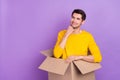 Photo of handsome young homeless man in carton box look empty space dreaming about his own home isolated on violet color Royalty Free Stock Photo