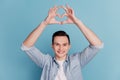 Photo of handsome young man showing heart symbol cupid valentine day isolated blue color background