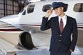 Portrait of handsome young pilot standing in front of private airplane Royalty Free Stock Photo