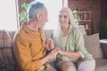 Photo of happy affectionate old couple sit sofa hold hands harmony love indoors inside house home flat Royalty Free Stock Photo