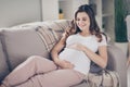 Photo of happy attractive charming young mother touch stomach lie sofa in apartment indoors inside house Royalty Free Stock Photo