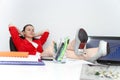 Relaxed and winning business woman sitting with her legs on desk and looking at her shoes Royalty Free Stock Photo
