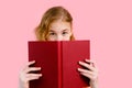 Photo of happy charming blonde girl posing with exercise books and smiling isolated over pink background Royalty Free Stock Photo