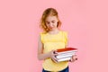 Photo of happy charming blonde girl posing with exercise books and smiling isolated over pink background Royalty Free Stock Photo