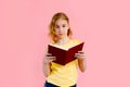 Photo of happy charming blonde girl posing with exercise books and smiling isolated over pink background Royalty Free Stock Photo