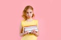 Photo of happy charming blonde girl posing with exercise books and smiling isolated over pink background Royalty Free Stock Photo