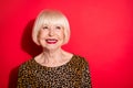 Photo of happy charming dreamy nice old woman look empty space smile positive isolated on red color background