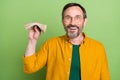 Photo of happy cheerful mature man hold hands cash money good mood isolated on green color background