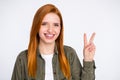 Photo of happy cheerful young beautiful smiling girl showing v-sign wear jacket isolated on grey color background Royalty Free Stock Photo