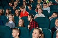 Photo of happy children watching movie in the cinema and laughing.