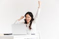 Photo of happy chinese businesswoman with long dark hair screaming with raised arms while working with documents and Royalty Free Stock Photo