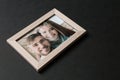 Photo of happy couple in frame with cracked glass on dark background. Concept of divorce Royalty Free Stock Photo