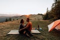Couple hikers sitting near the tent