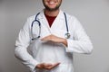 Photo of happy doctor in white coat with phonendoscope holding hands in form of circle Royalty Free Stock Photo