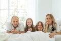 Photo of happy family lying on bed smiling in cozy home or apartment Royalty Free Stock Photo