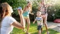 Photo of happy family playing with soap bubbles at house backyard garden. Family playing and having fun outdoors at Royalty Free Stock Photo