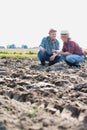 Happy Farmers examining soil in field