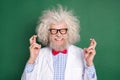 Photo of happy funky funny smiling crazy mad scientist with crossed fingers anticipation isolated on green color