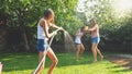 Photo of happy laughing family splashing water with water guns and garden hose at backyard. People playing and having Royalty Free Stock Photo